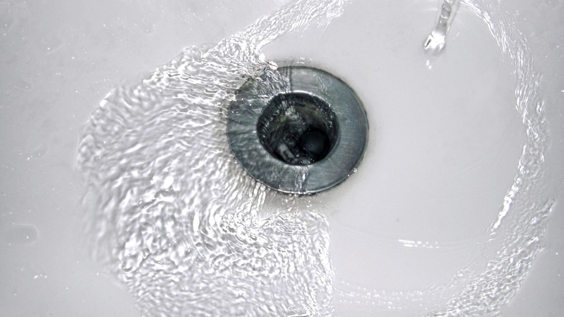 Close-up of a human eye with water splashing around the iris and pupil.